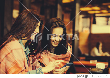 Two girl sitting listening to music 18325663