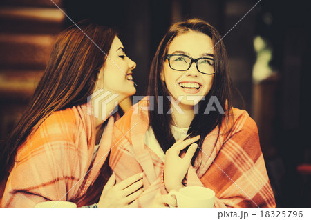 Two young and beautiful girls gossiping 18325796