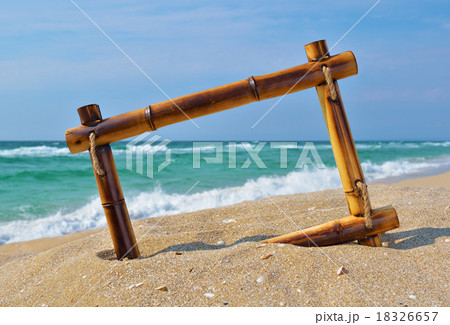 Seascape with bamboo frame on the beach sand Seascape with bamboo frame on the beach sand 18326657