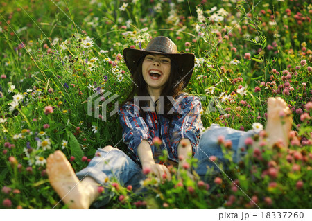 Happy American woman in a cowboy hat field wild flowers 18337260