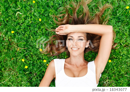 young woman in white dress lying on grass young woman in white dress lying on grass 18343077