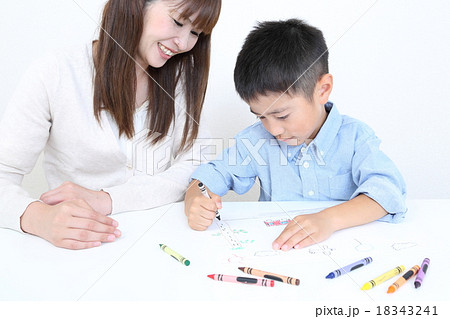 お絵描きする子供と母親の写真素材