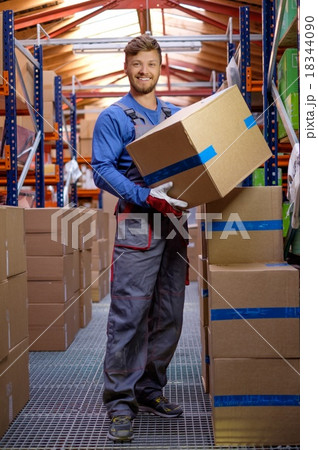 Porter carrying boxes in a warehouse 18344090