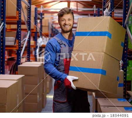 Porter carrying boxes in a warehouse Porter carrying boxes in a warehouse 18344091