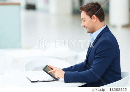 Young gentleman occupied with his tablet 18362235