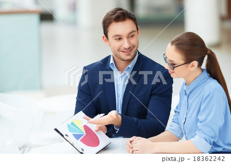 Two employees debating the chart. Two employees debating the chart. 18362242
