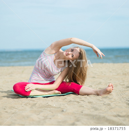 Young lady practicing yoga. Workout near ocean sea 18371755