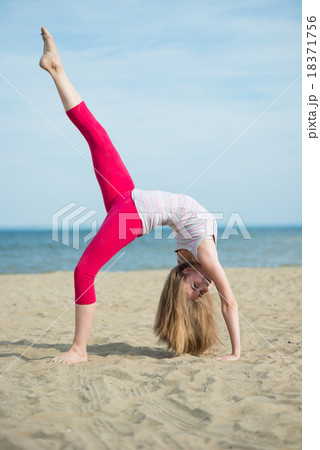 Young lady practicing yoga. Workout near ocean sea 18371756