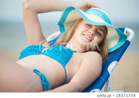 Young lady sunbathing on a beach. Beautiful woman 18371758