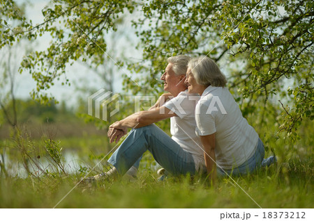 Senior couple sitting near lake 18373212