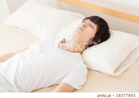ぐっすり寝る若い男性 18377863