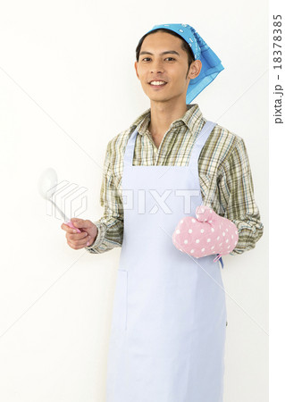 お玉を持ち料理をする若い男性イメージ 18378385