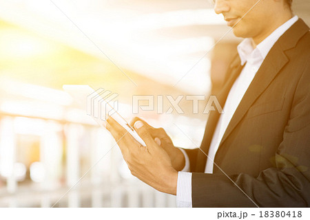 Businessman using tablet computer at train station 18380418