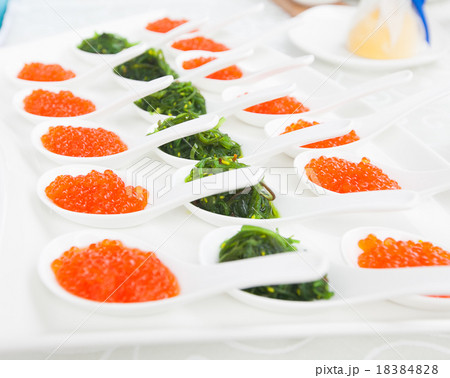 red caviar close-up in white spoons on banquet 18384828