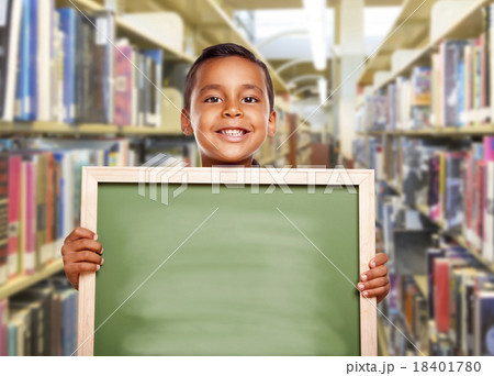 Smiling Hispanic Boy Holding Empty Chalk Board in Library Smiling Hispanic Boy Holding Empty Chalk Board in Library 18401780