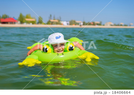 Little happy boy swimming at sea with rubber ring. Little happy boy swimming at sea with rubber ring. 18406664