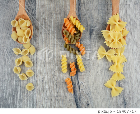 Three kinds of raw pasta in wooden spoons 18407717