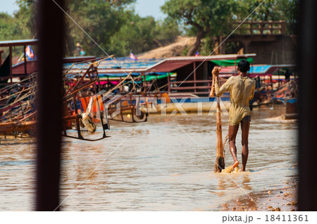 Man covered in mud with fishing net Man covered in mud with fishing net 18411361