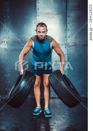 Sportsmen. fit male trainer man keeps the car tire 18412623