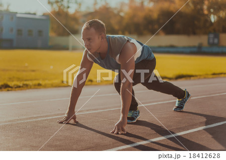 man standing in posture ready to run on treadmill. 18412628
