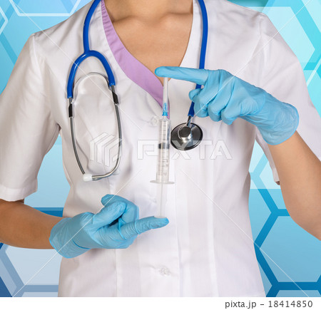 Doctor with stethoscope shows syringe. 18414850