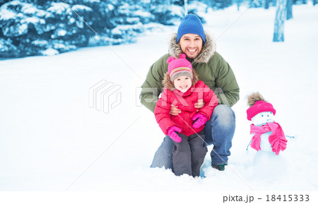 Happy family father and child girl makes snowman in winter Happy family father and child girl makes snowman in winter 18415333