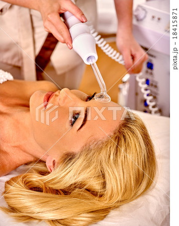 Young woman receiving darsonval facial massage. Young woman receiving darsonval facial massage. 18415871