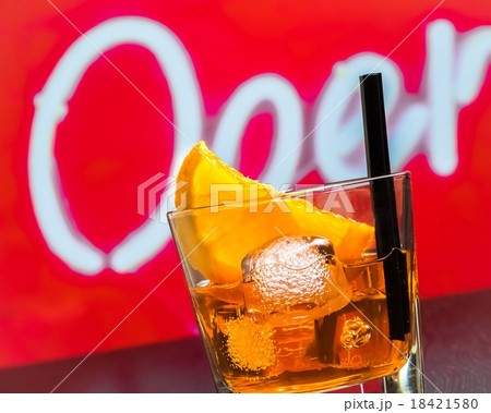 detail of glass of spritz aperitif aperol cocktail with orange slices and ice cubes on bar table, disco atmosphere background detail of glass of spritz aperitif aperol cocktail with orange slices and ice cubes on bar table, disco atmosphere background 18421580
