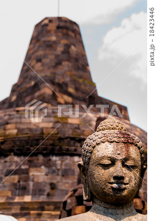 Buddha stone sculpure sitting in front of stupa 18423446