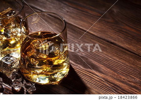 Glasses of whiskey with ice on wood 18423866