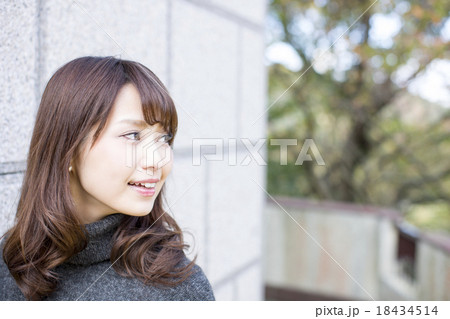 石壁の前でどこか遠くを見ている若い女性 18434514