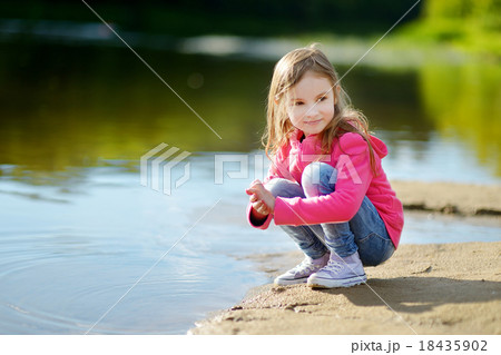 Adorable little girl playing by a river Adorable little girl playing by a river 18435902
