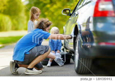 Happy family changing a car wheel 18436441