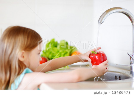 Adorable little girl washing vegetables Adorable little girl washing vegetables 18436473
