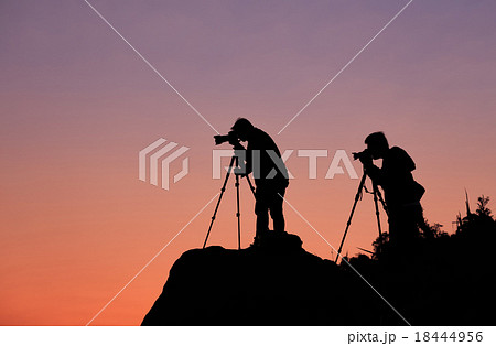 Silhouette of a photographer shooting a sunset  18444956