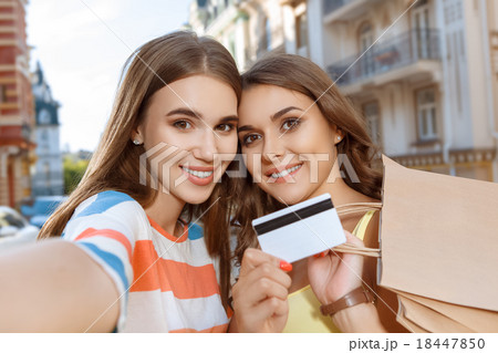 Two friends doing selfie with shopping bags 18447850