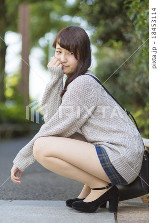 若い女性　ポートレート　しゃがむ　カメラ目線　はずし 18453114