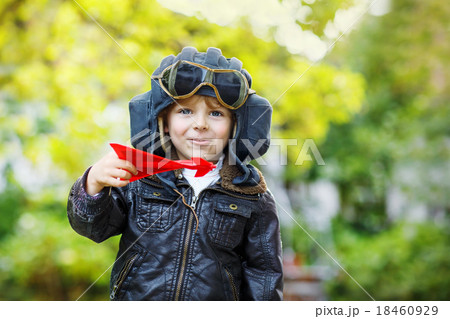 Little kid boy in pilot helmet playing with toy airplane Little kid boy in pilot helmet playing with toy airplane 18460929