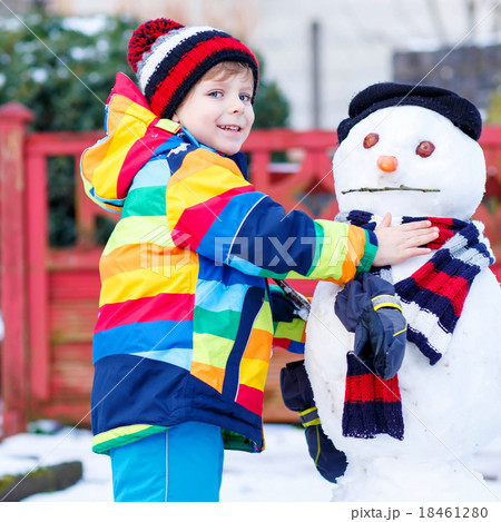 Funny kid boy making a snowman in winter 18461280