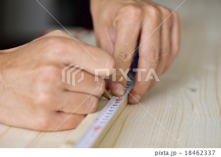 young man taking measurements in a wooden board 18462337