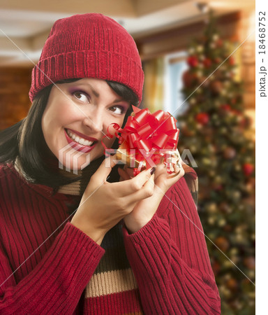 Woman Holding Wrapped Gift in Christmas Setting 18468752