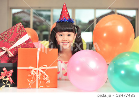 Happy Asian girl posing with balloons and presents Happy Asian girl posing with balloons and presents 18477435