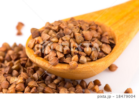 Uncooked buckwheat on wooden spoon Uncooked buckwheat on wooden spoon 18479004