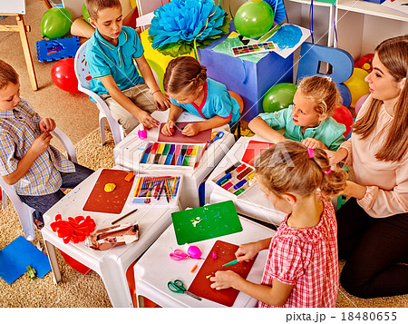 Kids holding colored paper and glue on table in Kids holding colored paper and glue on table in 18480655