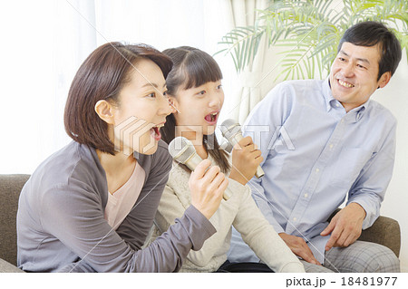 家族でカラオケを熱唱する家族イメージの写真素材
