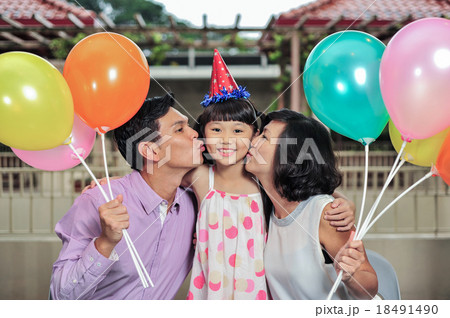 Father and Mother kissed daughter at her birthday Father and Mother kissed daughter at her birthday 18491490