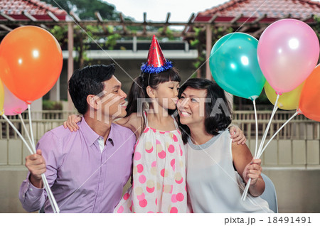 Asian girl show love by kissing her mom at a party Asian girl show love by kissing her mom at a party 18491491