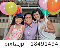 Asian family of three posing for photo at party 18491494