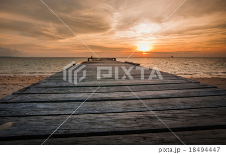 wooden jetty facing sun set down 18494447