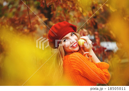 Lovely girl in beret sweater holding ripe apple Lovely girl in beret sweater holding ripe apple 18505011